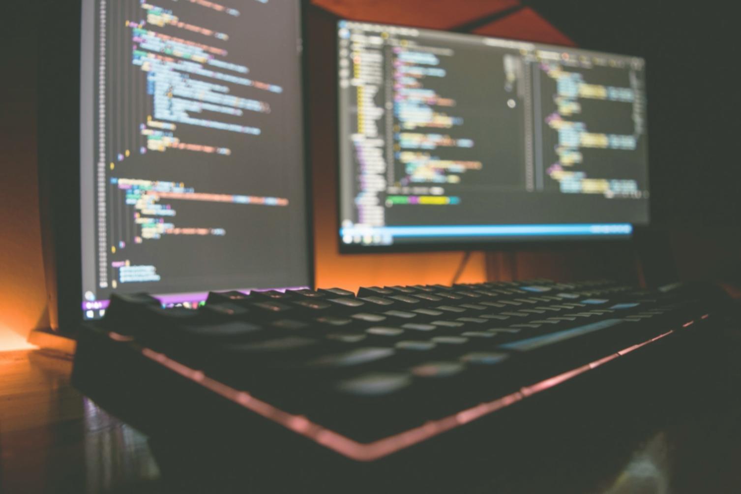Studenti al lavoro su progetto di game design con postazioni professionali